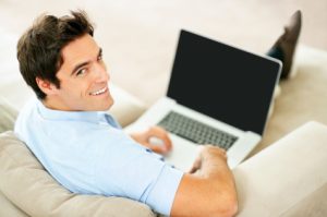 Portrait of a relaxed young guy using laptop at home